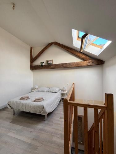 a bedroom with a bed and a skylight at L'Aile de Fontainebleau in Fontainebleau