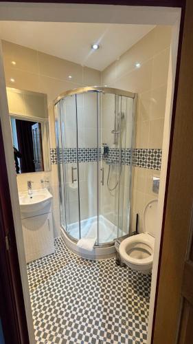 a bathroom with a shower and a toilet and a sink at The Marker Hotel in London