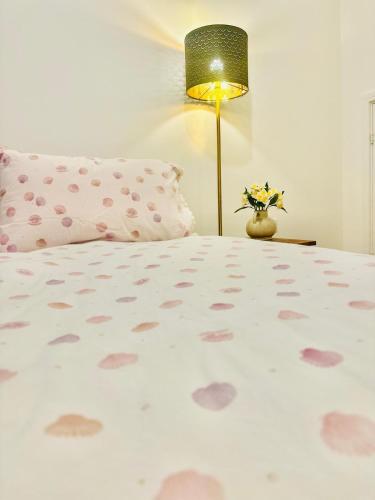 a bedroom with a bed with a pillow and a lamp at Gilded Nest-Room with Detached Bath- Ideal for ONE- WIFI, Car Parking-Shared House in Newarthill