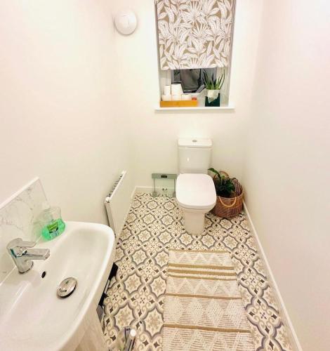 a bathroom with a white toilet and a sink at Gilded Nest-Room with Detached Bath- Ideal for ONE- WIFI, Car Parking-Shared House in Newarthill