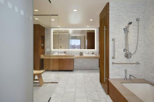 a bathroom with two sinks and a shower and a tub at The Alexander, Autograph Collection in Indianapolis