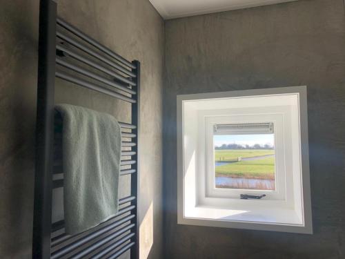 a bathroom with a window and a towel at By de barte in Beers