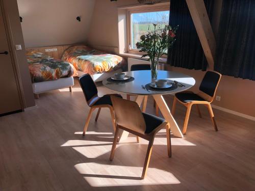 a room with a table and chairs and a bed at By de barte in Beers