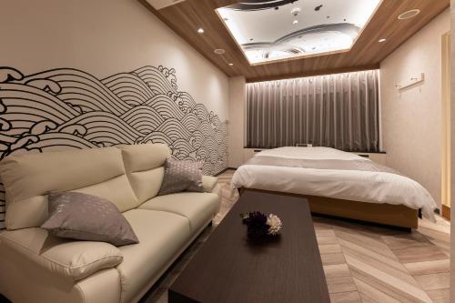 a living room with a couch and a bed at Carnet (Adult Only) in Amagasaki