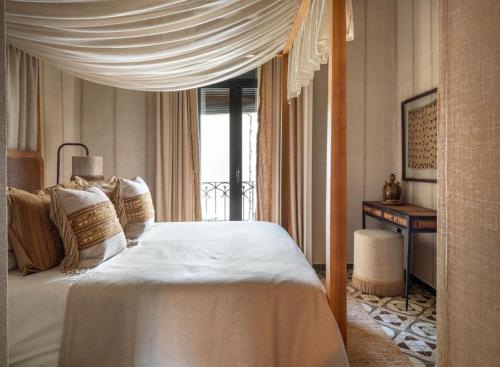 a bedroom with a white bed with a canopy at Casa Con Destino in Jalón