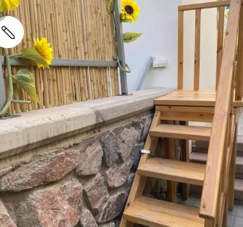 a set of stairs next to a wall with sunflowers at Studio Caroline in Eilat