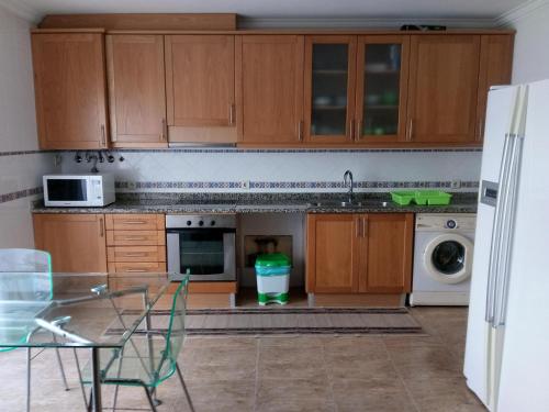 a kitchen with wooden cabinets and a sink and a dishwasher at House Victoria in Nazaré