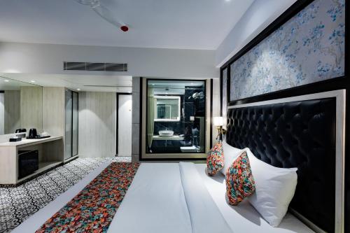 a hotel room with a bed and a large wall at Sio Suites in Navi Mumbai