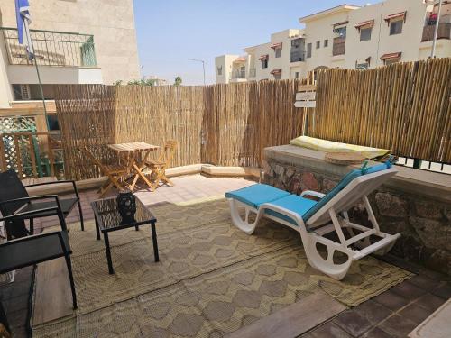 a patio with a chair and a table and a fence at Studio Caroline in Eilat