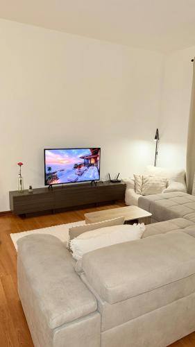 a living room with two white couches and a flat screen tv at Apartment in Leipzig in Leipzig