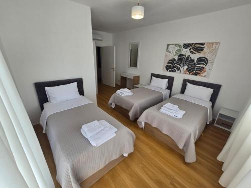 a room with three beds in a room at Shkodra Harmony Residences in Shkodër