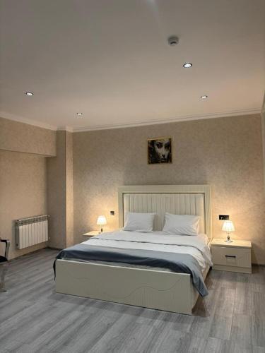 a bedroom with a large bed and two night stands at Grand Teatro Hotel in Ganja