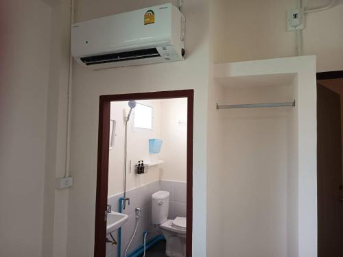 a bathroom with a white toilet and a sink at Doctor Thanut Hostel in Ubon Ratchathani