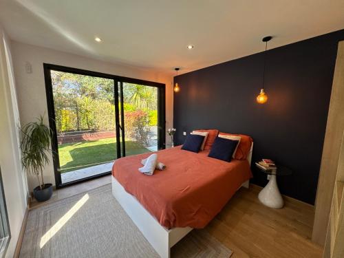 a bedroom with a large bed and a large window at Villa bord de mer in Labenne