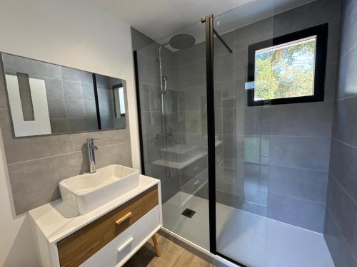 a bathroom with a sink and a shower at Villa bord de mer in Labenne