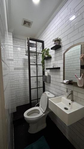 a white bathroom with a toilet and a sink at Villa Bali Rice Field in Sukaraja
