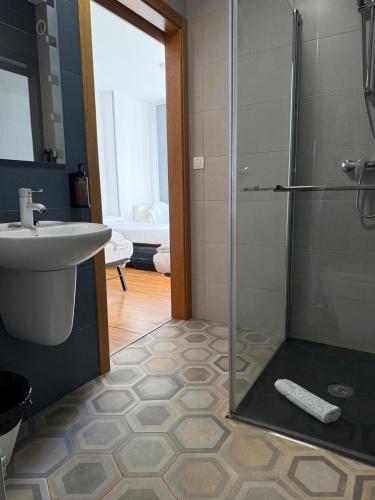 a bathroom with a glass shower and a sink at Albergue Alfonso II in Melide