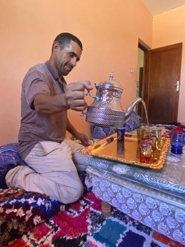 a man sitting on the floor with a tea kettle at Sidi hssain in Marrakesh