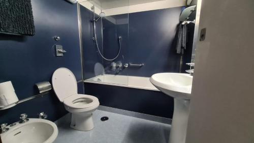 a blue bathroom with a toilet and a sink at Residenza 402 in Ivrea