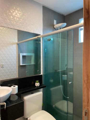 a bathroom with a toilet and a glass shower at Studio compacto em Camboriú in Camboriú