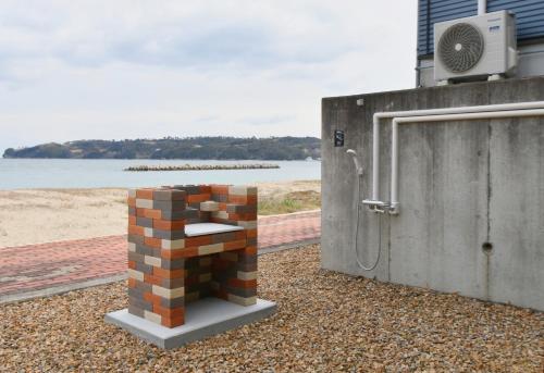 a brick pillar next to a building next to the beach at シーサイド興津 in Sanuki