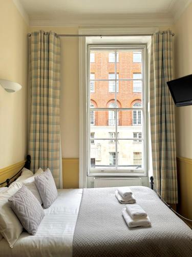 a bedroom with a bed and a large window at The Marker Hotel in London