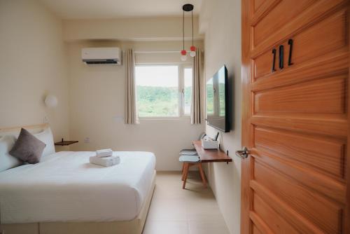 a bedroom with a bed and a door and a desk at 綠島 棲間民宿 Green Island Roost B&B in Green Island