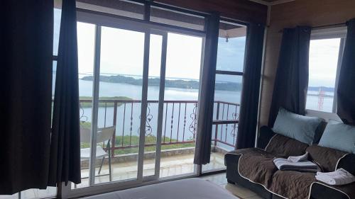 a living room with a couch and a view of the ocean at Mi Refugio suite in Quebrada Jones