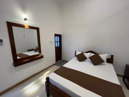 a bedroom with a bed with a large mirror at Cottage Fifty One in Kandy