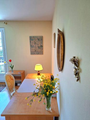 a room with a table with a vase of flowers on it at respite finaly in Geneva