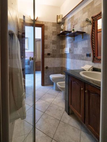 a bathroom with a toilet and a sink and a mirror at Affittacamere Le Palme in Ospedaletti