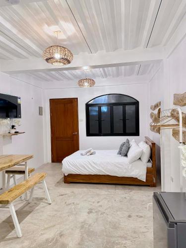 a bedroom with a bed and a tv on the wall at BeaMare Suites in Bantay