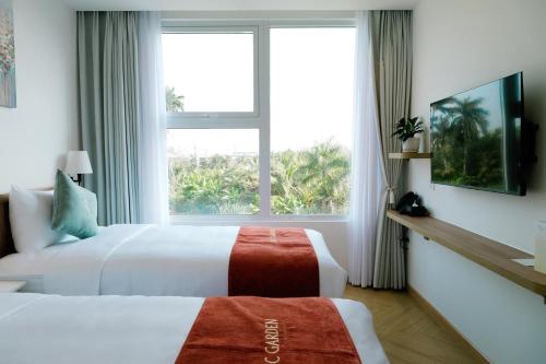a hotel room with two beds and a window at Sadec Garden Boutique Hotel in Ấp Tân Thành (2)