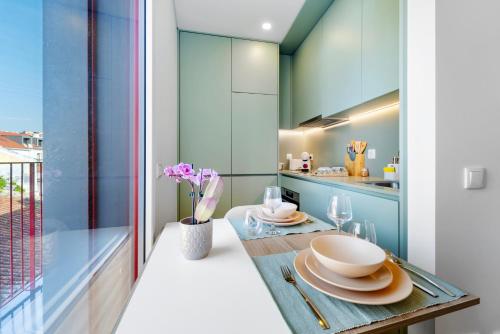 a kitchen with blue cabinets and a wooden table at Castle Boutique Studio in Leiria