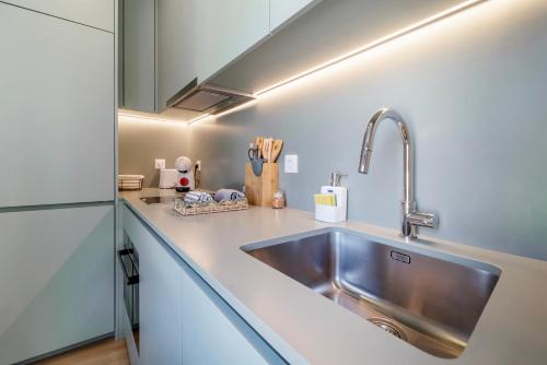 a kitchen with a sink and a refrigerator at Castle Boutique Studio in Leiria
