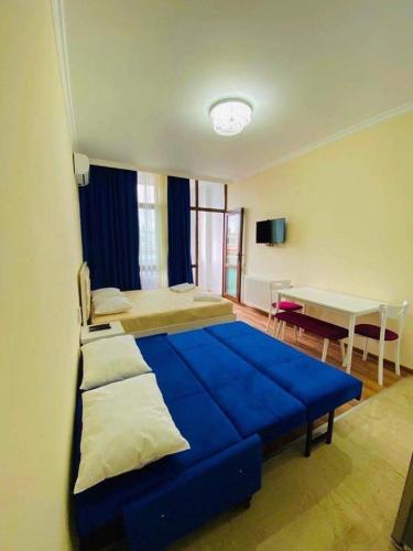 a bedroom with a large blue bed and a desk at Apartamenti Panorama in Kobuleti