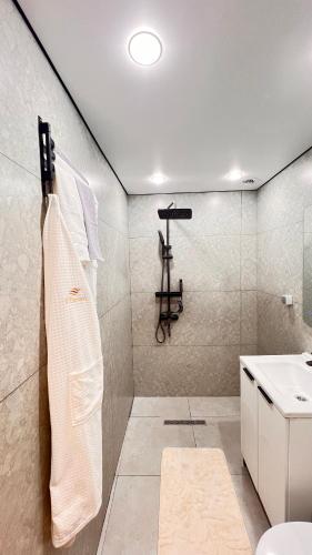 a bathroom with a sink and a towel rack at Лофт отель 11eleven in Shymkent