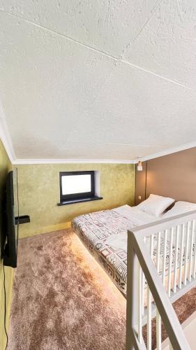 a bedroom with a bed and a window and a television at Лофт отель 11eleven in Shymkent
