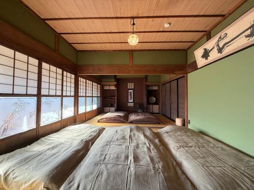 a large bedroom with a large bed in the middle at ゐらくさ in Yaizu