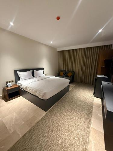 a bedroom with a large bed and a desk at نون Noon in Medina