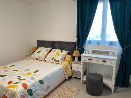 a bedroom with a bed and a desk and a window at L'Appart'CASANELLA in Sarzeau