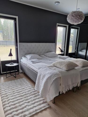 a bedroom with a large bed and a rug at Huvilarannalla in Sotkamo