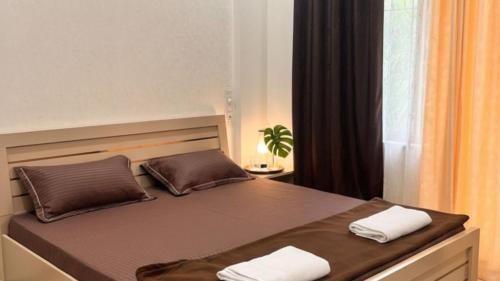 a bed with two white towels on top of it at Motus Mountain view Hotels in Jambhulpāda