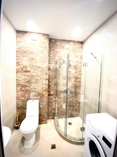 a bathroom with a toilet and a glass shower at Apartamenti Panorama in Kobuleti