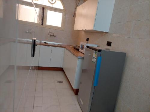 eine kleine Küche mit Kühlschrank und Fenster in der Unterkunft شقق نسائم ورد in Ta'if