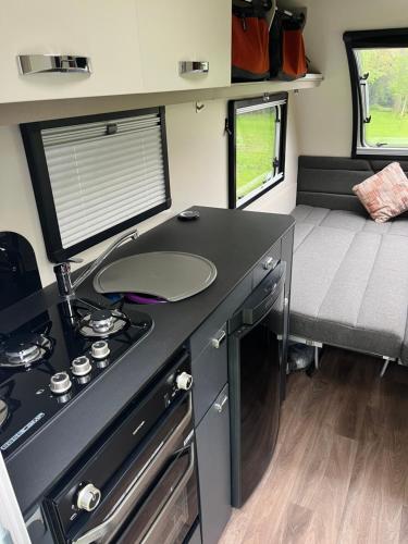 a kitchen with a counter and a stove in a caravan at Camping pod in Greatham