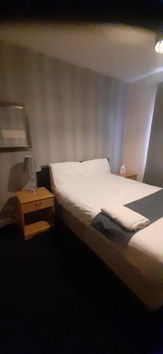 a bedroom with a bed and a table with a lamp at Our Guests Are Royal (EL) Wellingborough in Wellingborough