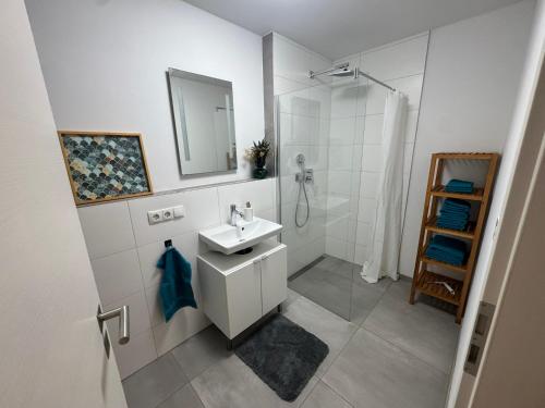 a white bathroom with a sink and a shower at Schöne Wohnung mit eigenem Eingang Souterrain in Walldorf