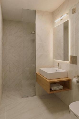 a bathroom with a sink and a glass shower at Hotel Perunika in Golden Sands