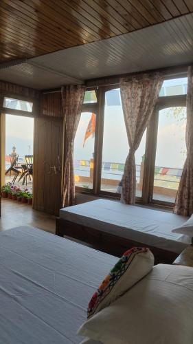 a bedroom with two beds with a view of the ocean at Dafey Homestay in Darjeeling